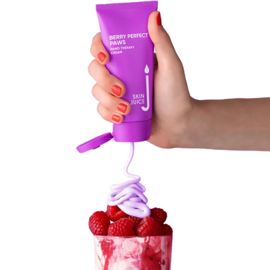 Skin Juice Perfect Paws hand cream in purple tube being squeezed onto raspberries and yogurt, moisturizing treatment for dry hands.