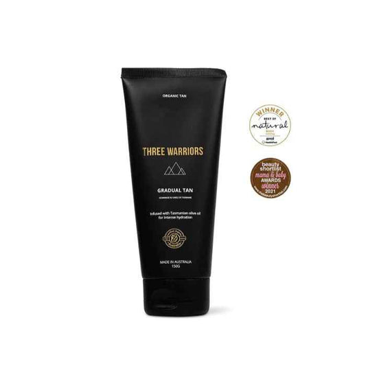 Three Warriors Natural Gradual Tan tube with award badges for organic, hydrating, streak-free self-tanning lotion