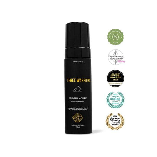 Three Warriors Self Tan Mousse bottle with award badges, offering a flawless, streak-free glow with organic ingredients.